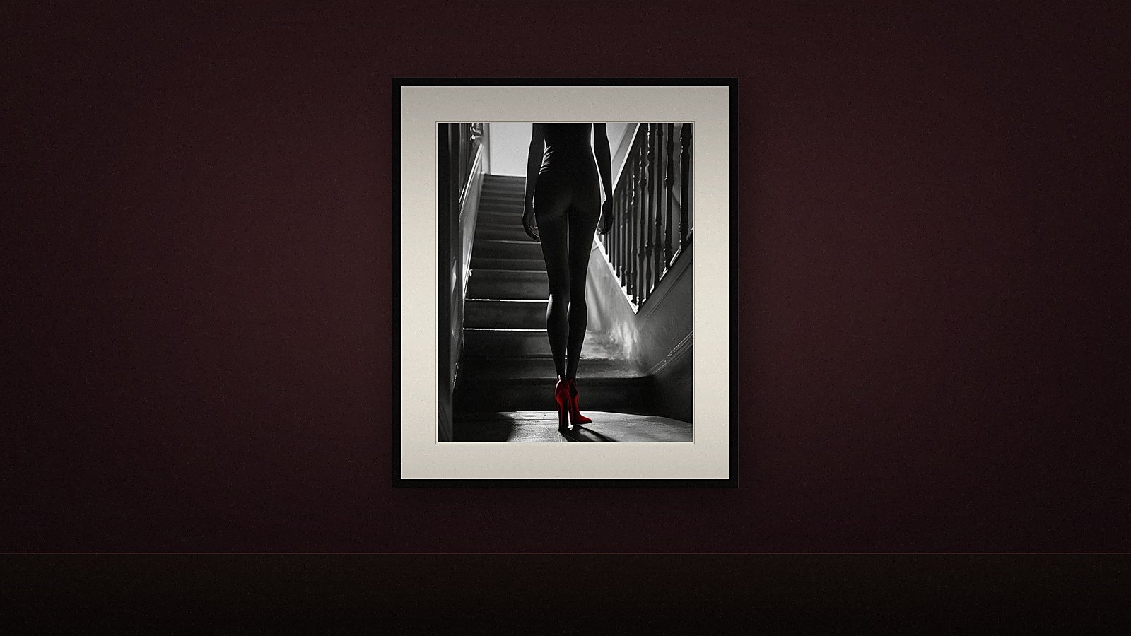 Dunkle Wandfarbe 2026 in tiefem Oxblood mit einem schwarz gerahmten Schwarzweiß-Fine-Art-Print, dessen breites cremefarbenes Passepartout den Kontrast zur Wand herstellt